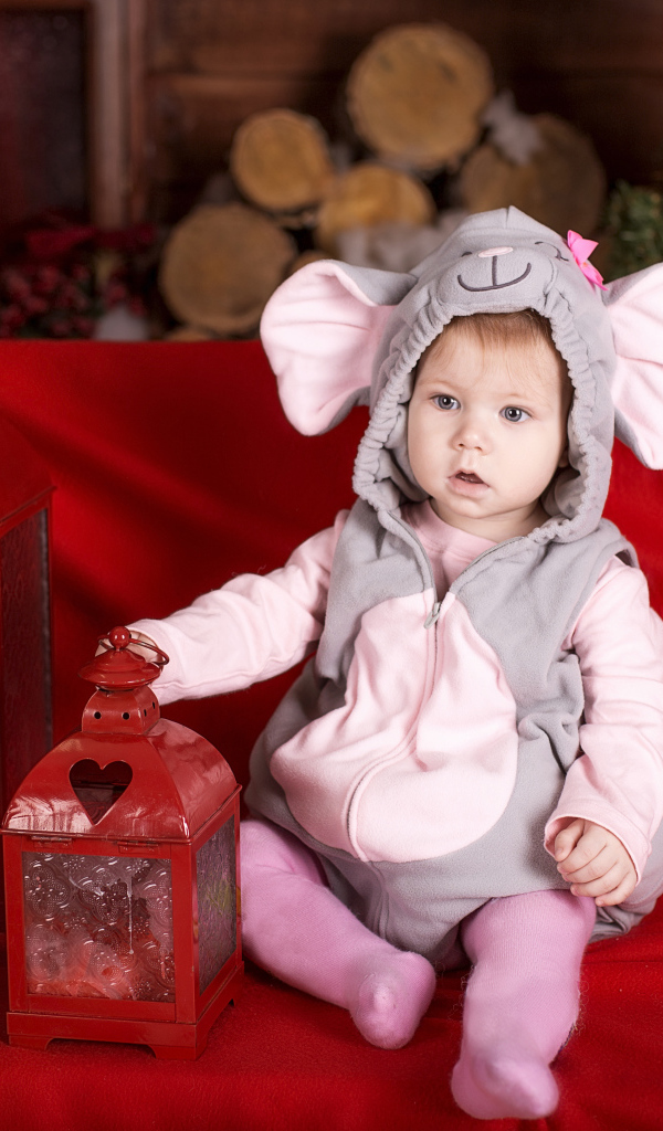 Маленький мальчик в костюме мышонка с фонарями на диване