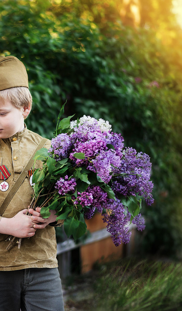 Маленький мальчик с девочкой в военной форме с букетом сирени на 9 мая 