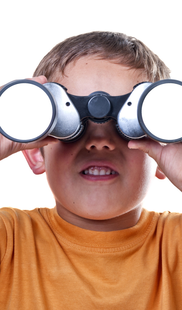 Маленький мальчик с биноклем на белом фоне