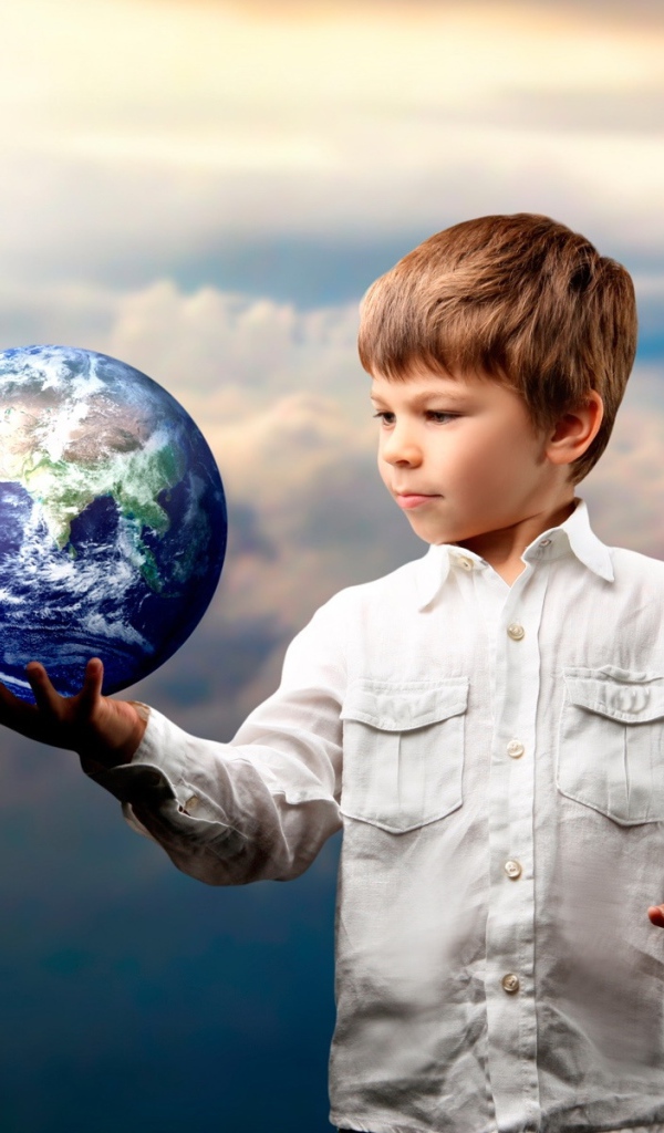 Маленький мальчик с планетой земля в руке