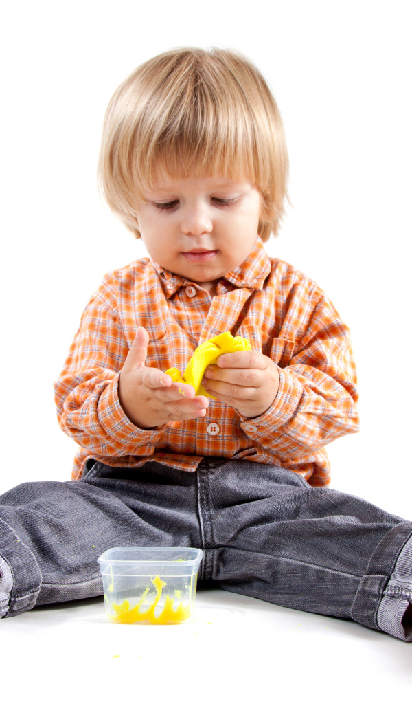 Маленький мальчик с игрушкой на белом фоне