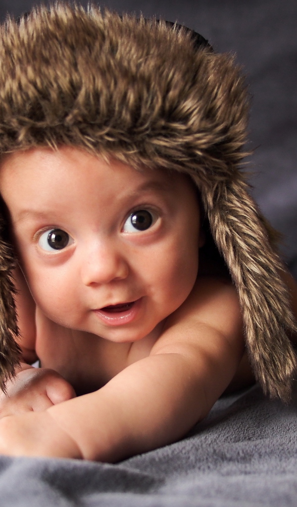 Маленький кареглазый ребенок в теплой шапке