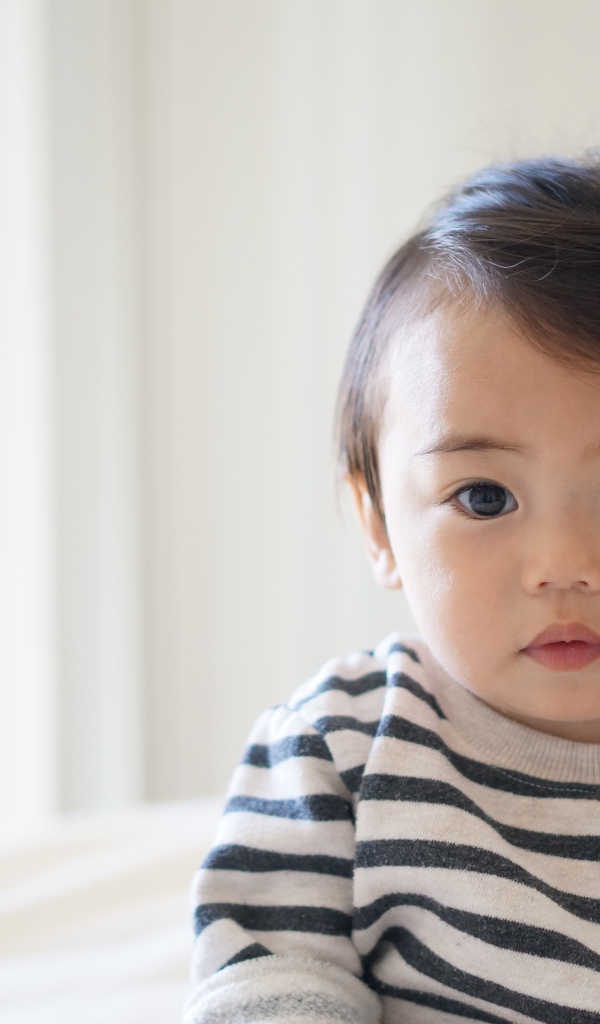 Маленький кареглазый мальчик в полосатом свитере