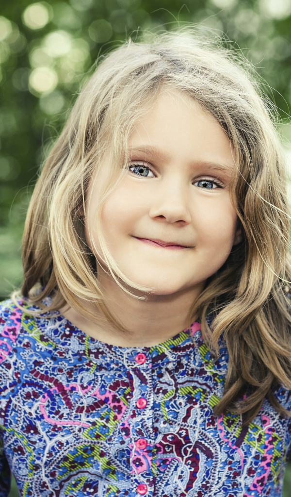 Маленькая милая голубоглазая девочка на качели