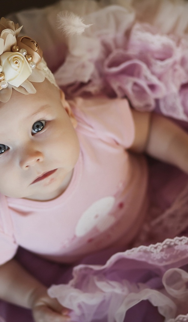 Маленькая милая девочка в пышном платье с повязкой на голове