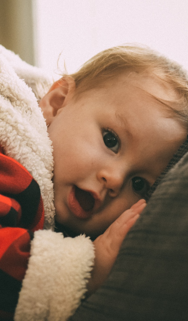 Маленький забавный малыш лежит на диване