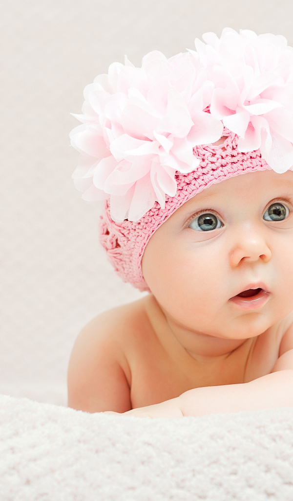 Маленькая девочка в вязаной шапке с цветами