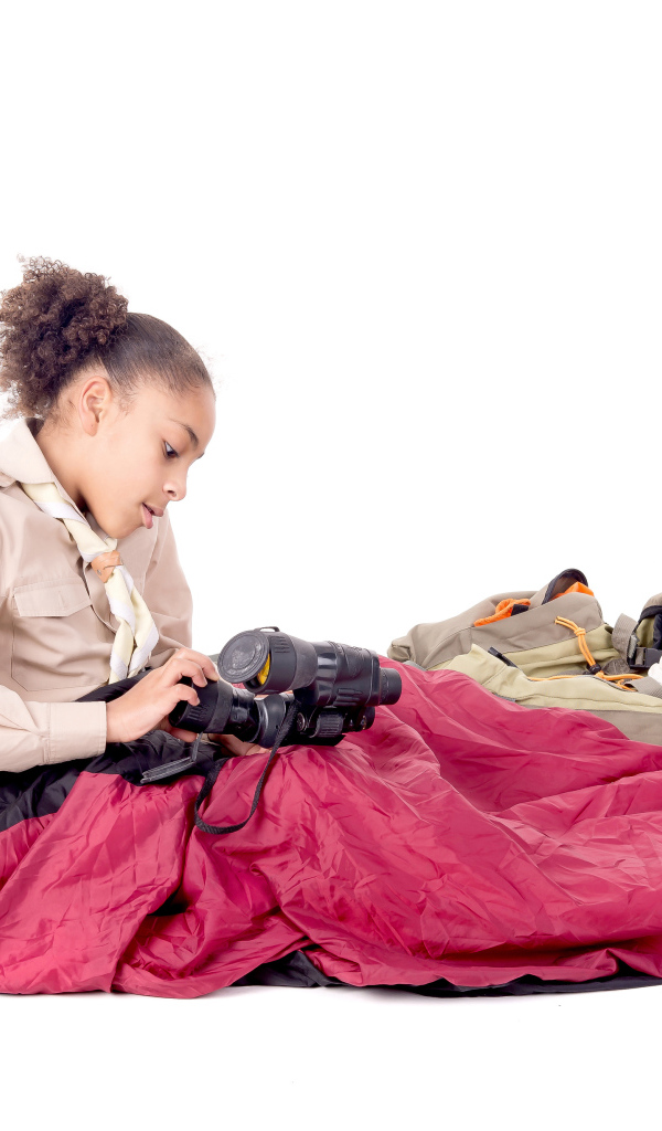 Маленькая девочка в спальном мешке с биноклем