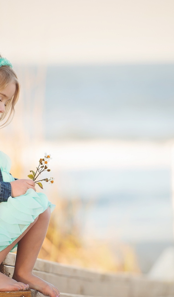 Маленькая девочка сидит на мосту