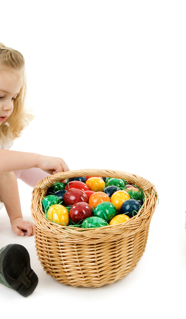 Маленькая девочка с корзиной крашеных яиц и игрушечным кроликом