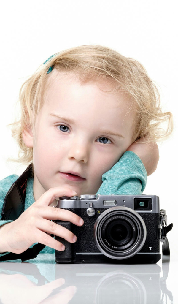 Маленькая девочка с фотоаппаратом на белом фоне