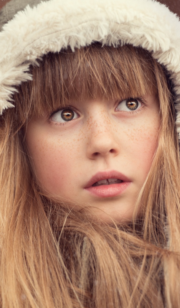 Маленькая девочка с веснушками на лице в капюшоне 