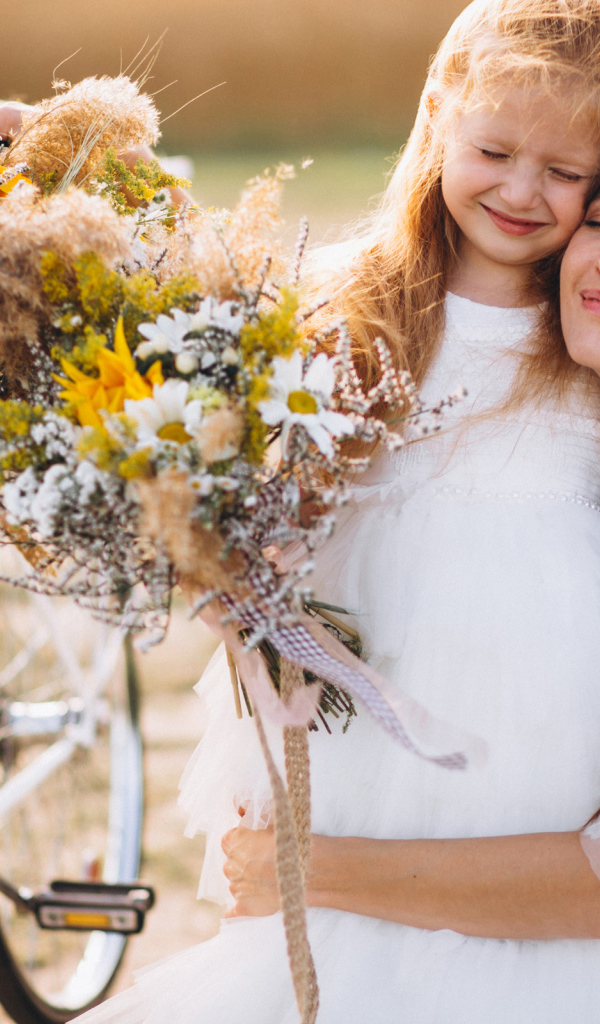 Маленькая девочка с мамой у велосипеда