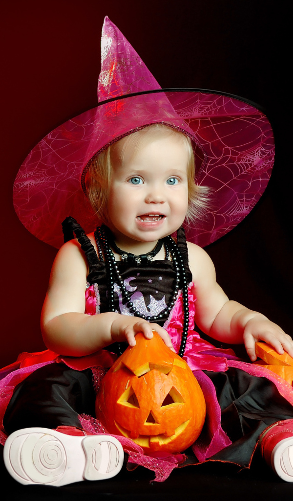 Маленькая девочка с тыквой в костюме на праздник Хэллоуин 