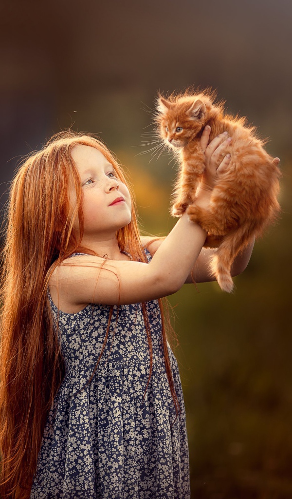 Маленькая рыжеволосая девочка с рыжим котенком в руках