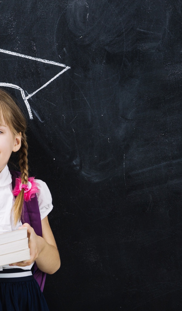 Маленькая школьница с книгами у доски 