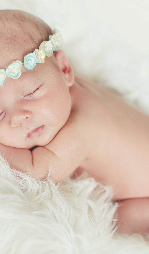 Маленький спящий ребенок на меховом покрывале