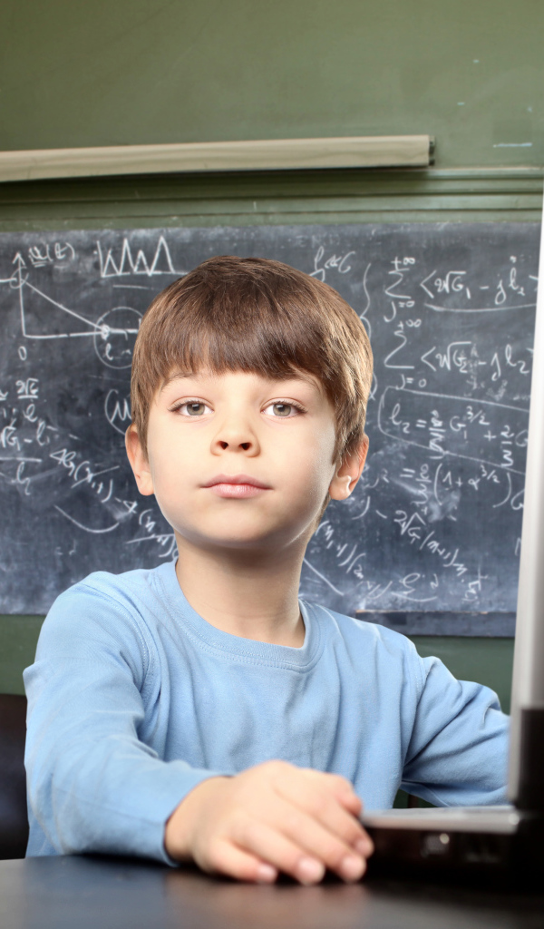 Мальчик школьник делает уроки за ноутбуком