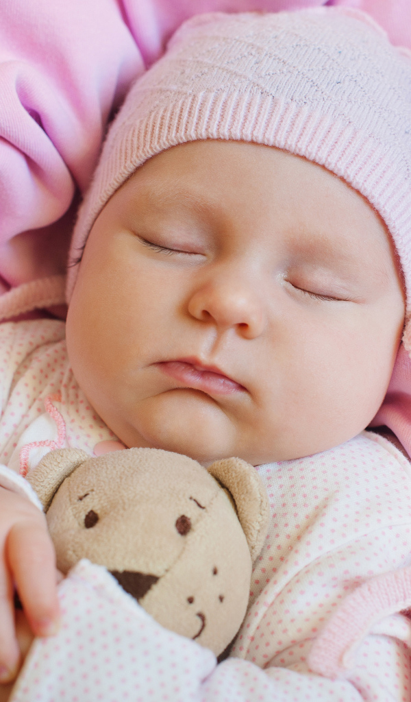 Спящий ребенок обнимает любимую игрушку