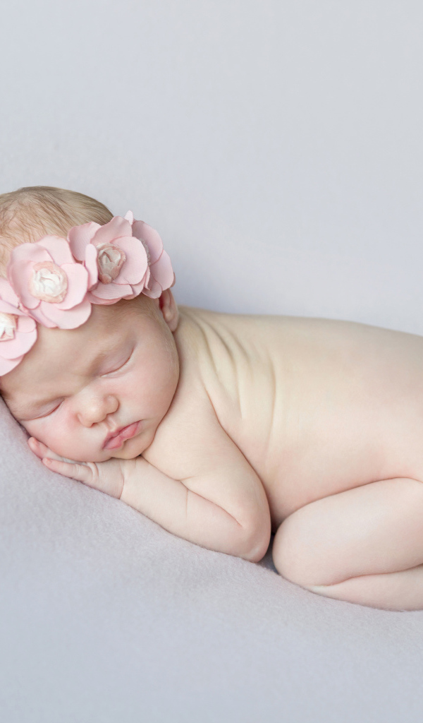 Спящая девочка с розовым венком на голове