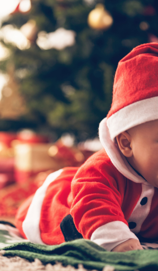 Улыбающийся малыш в новогоднем костюме у елки