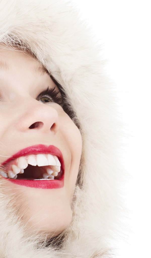 Улыбающаяся девушка в меховом капюшоне на белом фоне