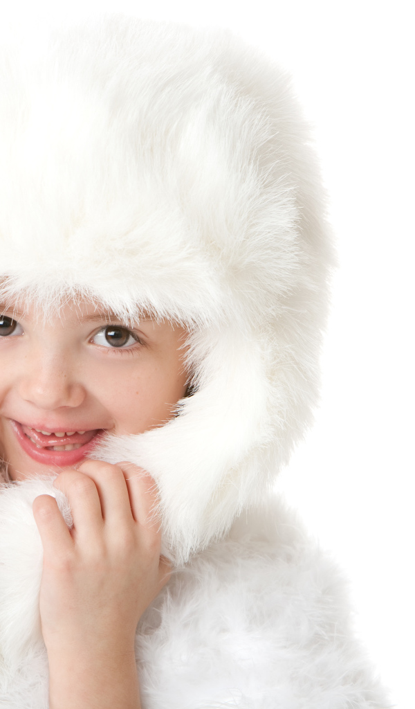 Улыбающаяся маленькая девочка в белой меховой шапке