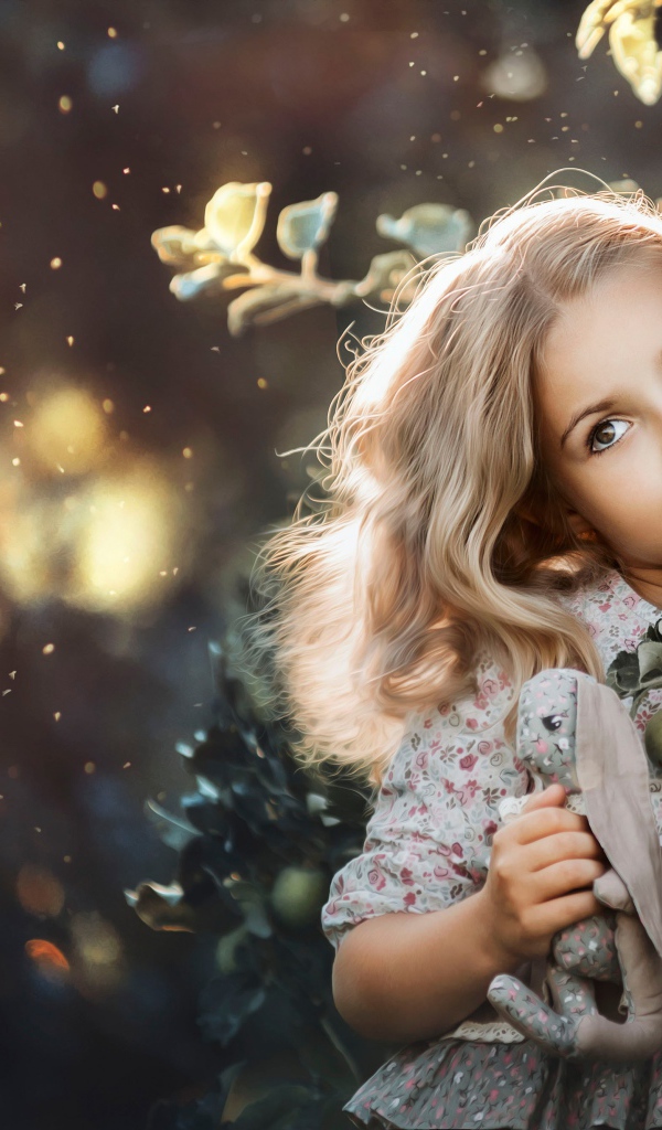 Маленькая девочка стоит у ветки с яблоками