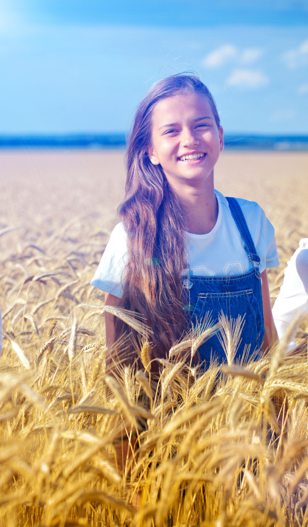 Три девочки на поле с желтой пшеницей