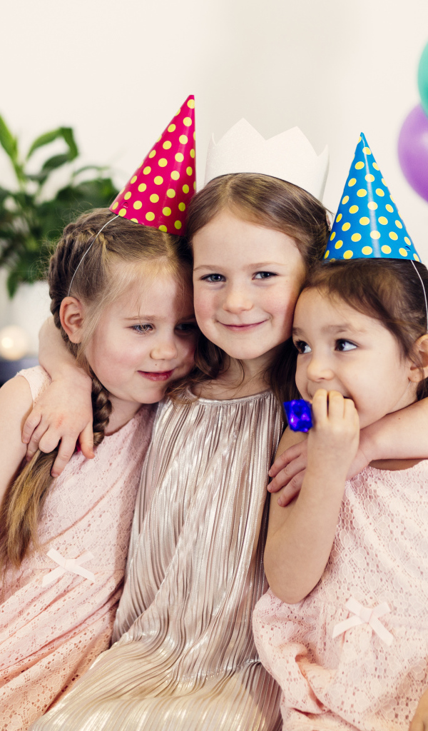 Три маленькие девочки в праздничных колпаках