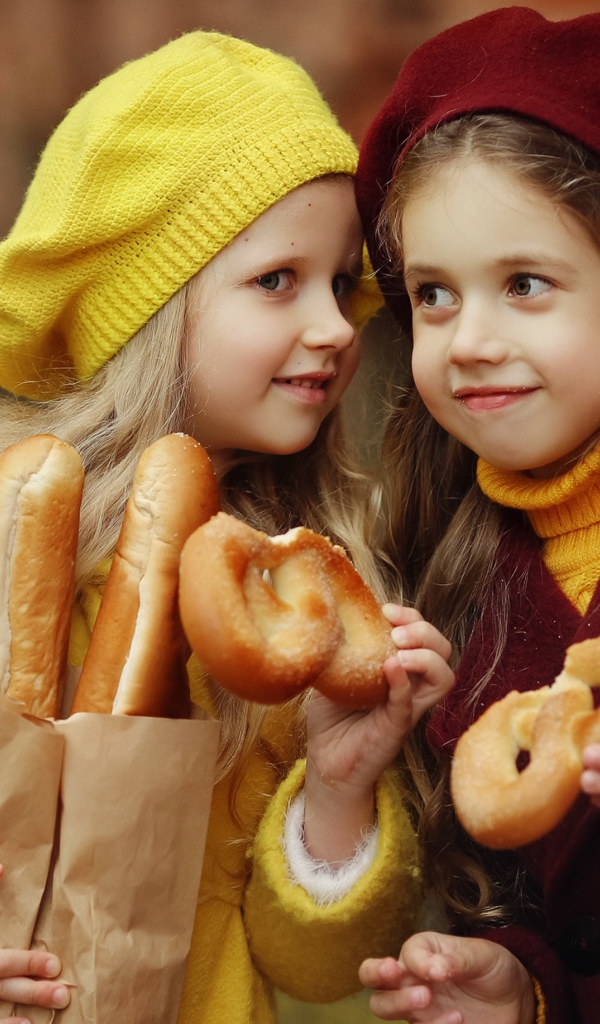 Две маленькие девочки с булочками 