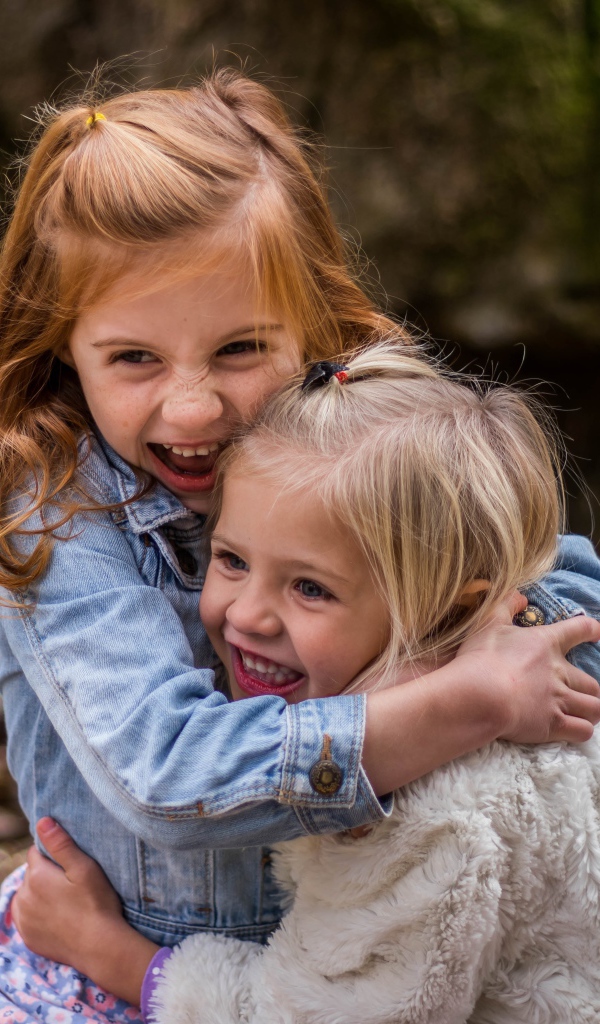 Две маленькие сестры обнимают друг друга 