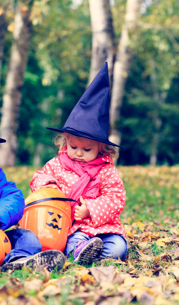 Маленькие мальчик и девочка в лесу на Хэллоуин 