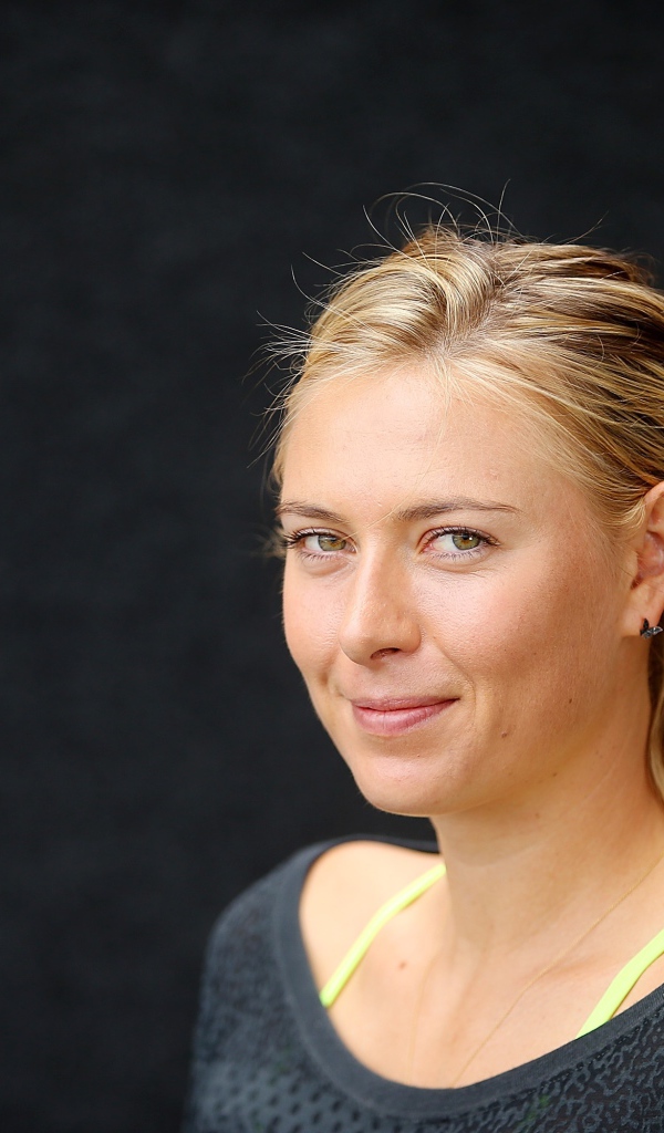 Улыбающаяся блондинка, теннисистка Мария Шарапова на сером фоне