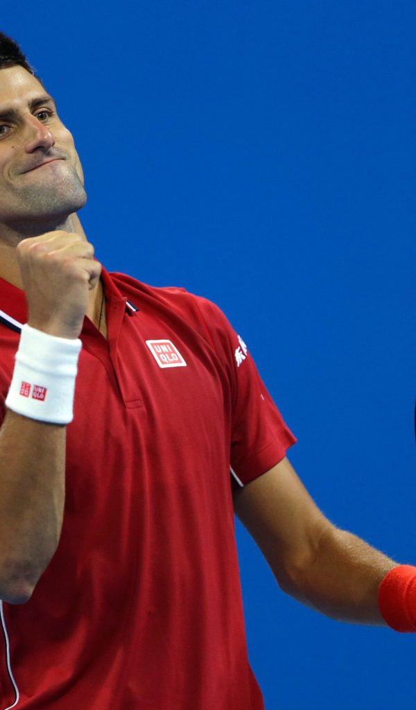 Теннисист Новак Джокович с ракеткой радуется на корте