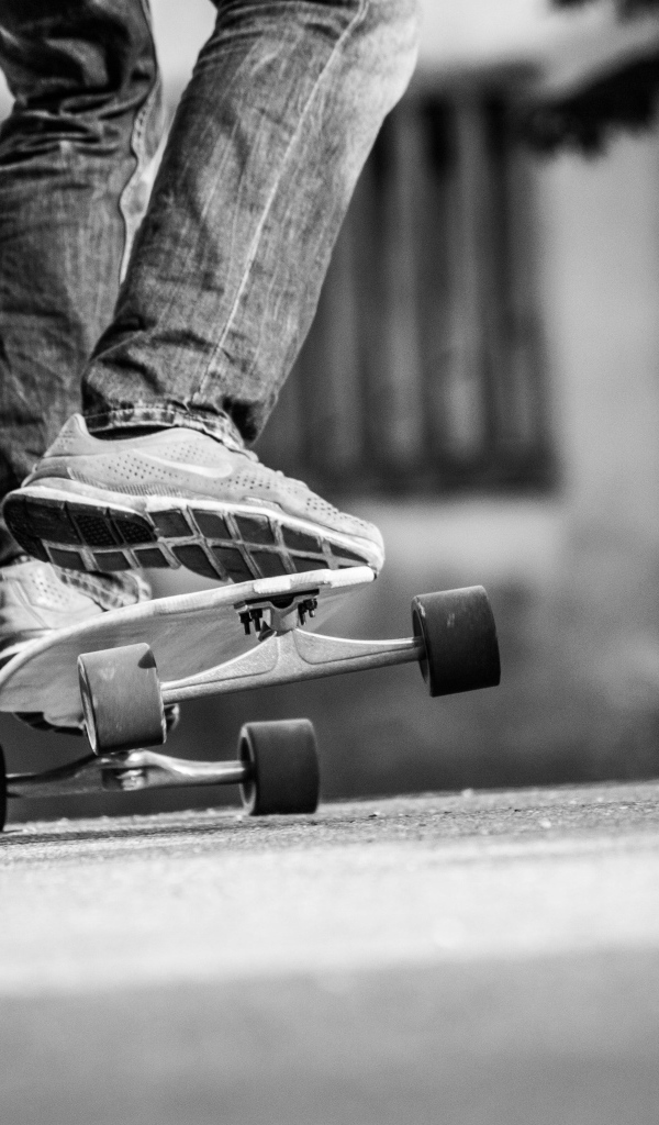 Парень катается на скейтборде по асфальту