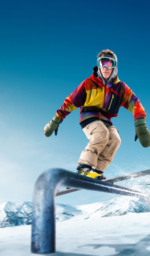 Молодой парень катается на лыжах на заснеженной горе в лучах солнца