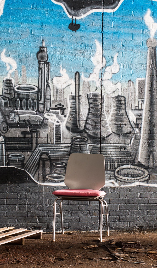 Стул стоит у кирпичной стены с граффити