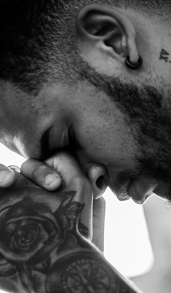 Мужчина с татуировками на руке и шее