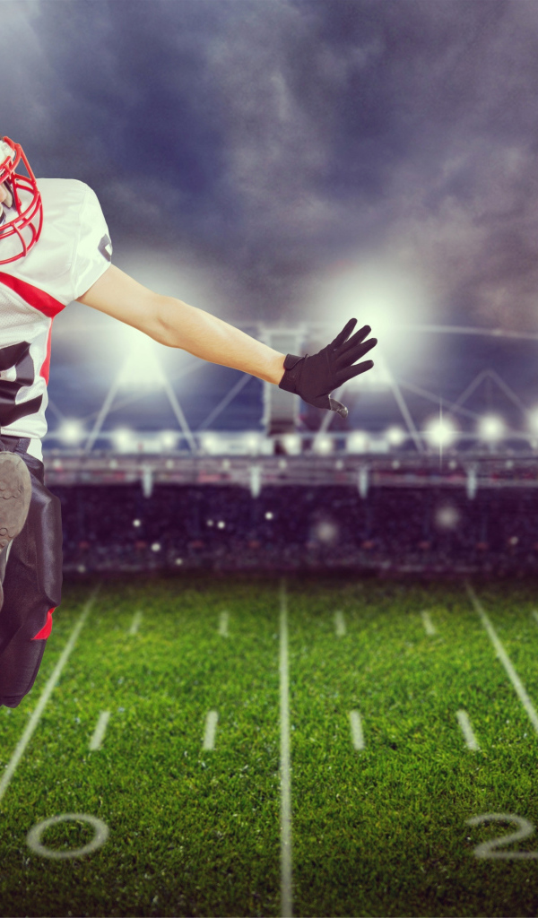 Игрок в американский футбол с мячом на поле