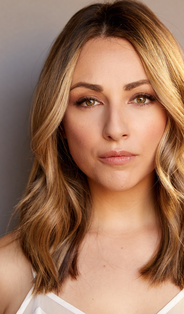 Красивая блондинка Никки Поснер на сером фоне 