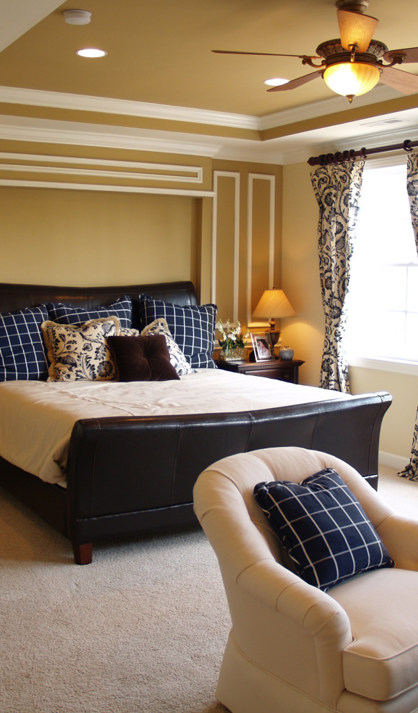 Спальня с большой кожаной кроватью и креслами 
