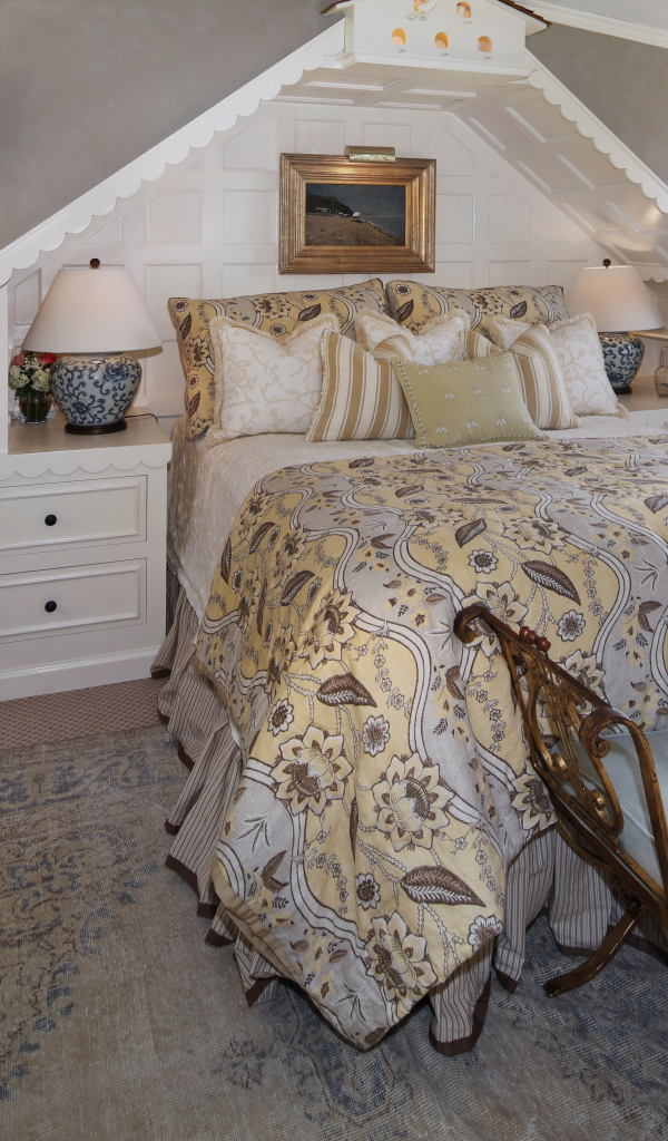 Спальня с большой просторной кроватью и диваном у окна 