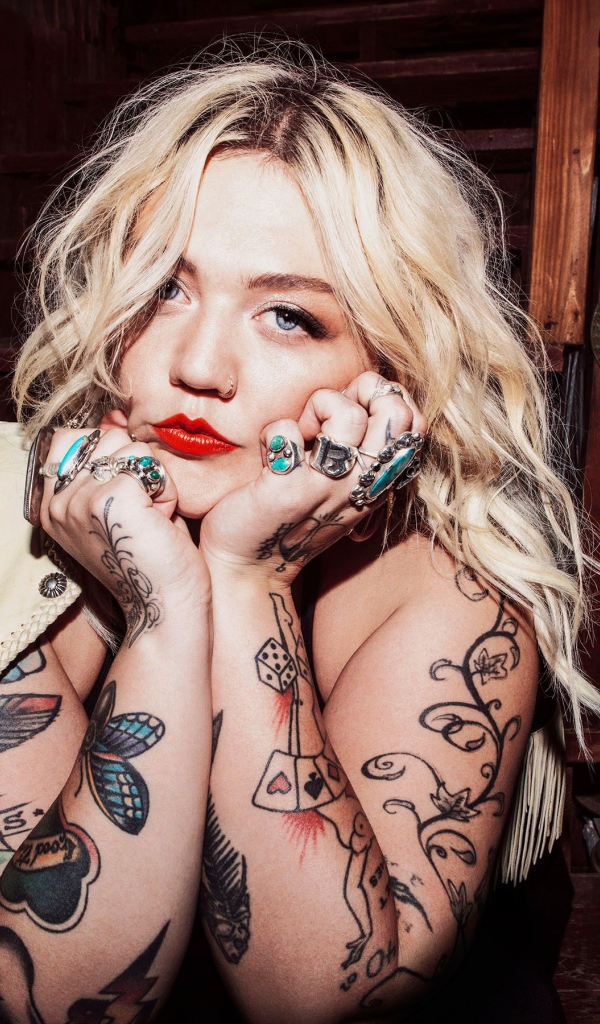Голубоглазая блондинка с татуировками на руках
