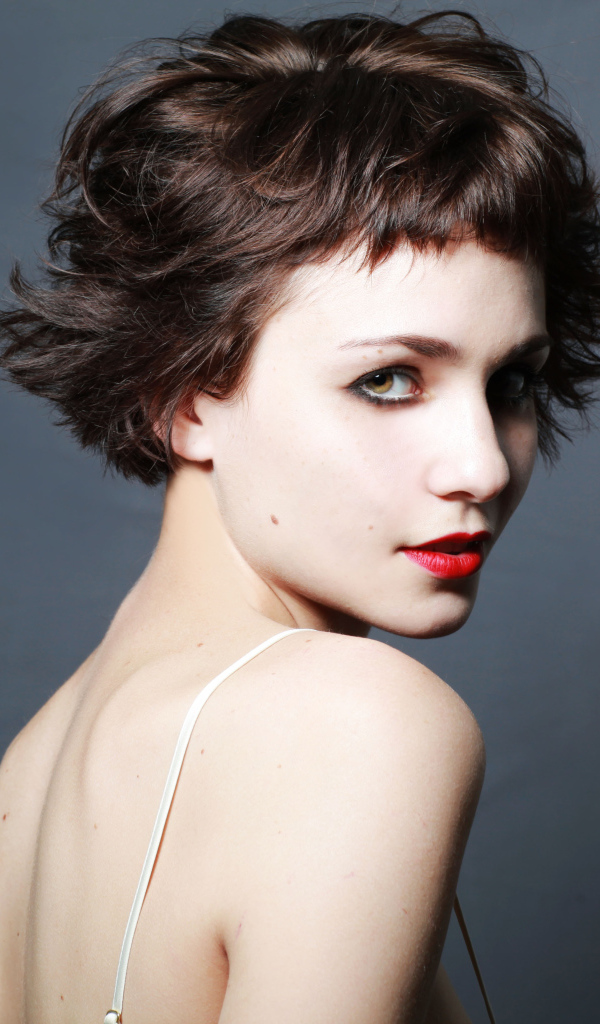 Яркая девушка с короткой стрижкой, актриса Таппенс Мидлтон на сером фоне