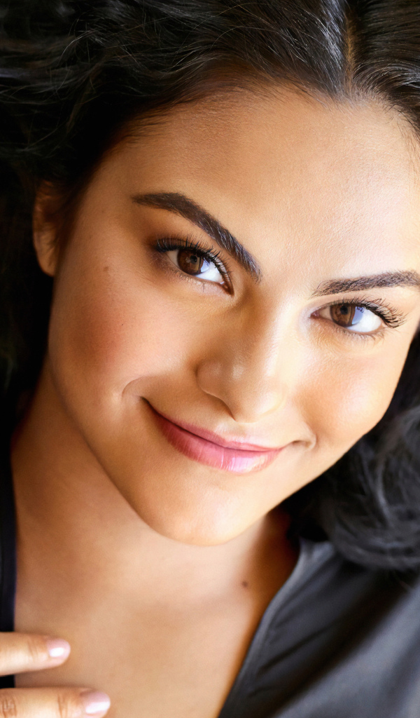 Кареглазая актриса Камила Мендес лежит на кровати 