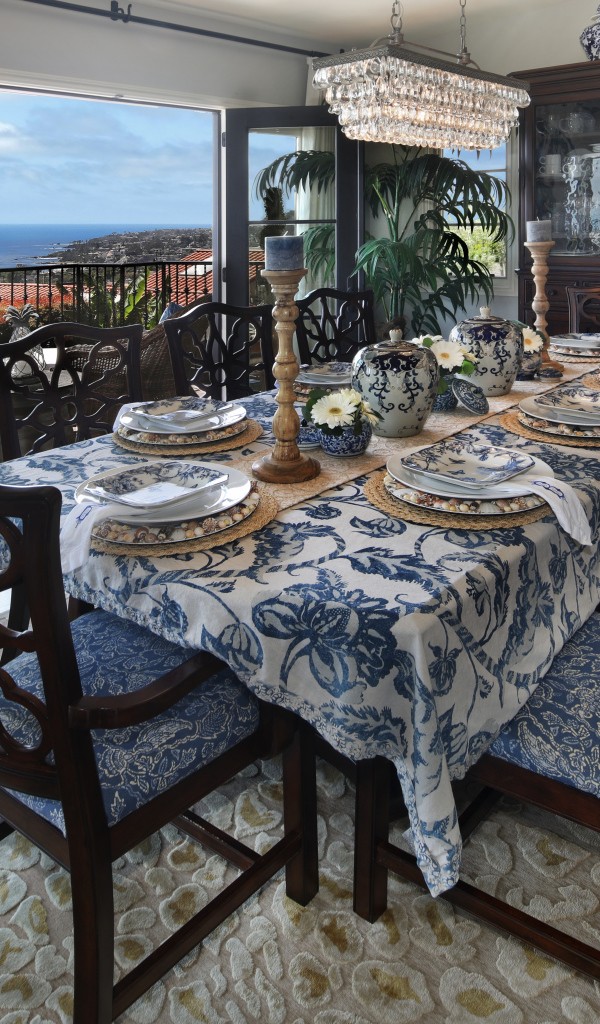 Столовая комната с большим дубовым столом  и красивой посудой