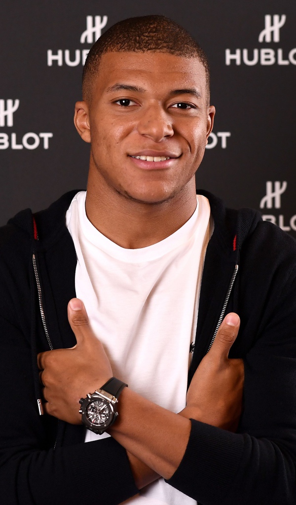 Футболист Килиан Мбаппе в костюме с часами на руке