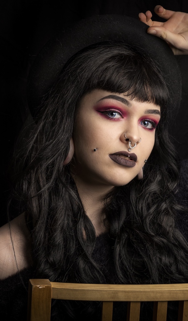 Девушка неформалка с черной шляпе с пирсингом на лице