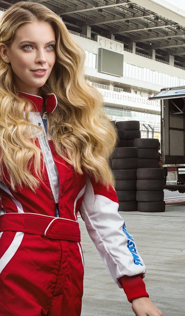 Девушка гонщица с шлемом в руках